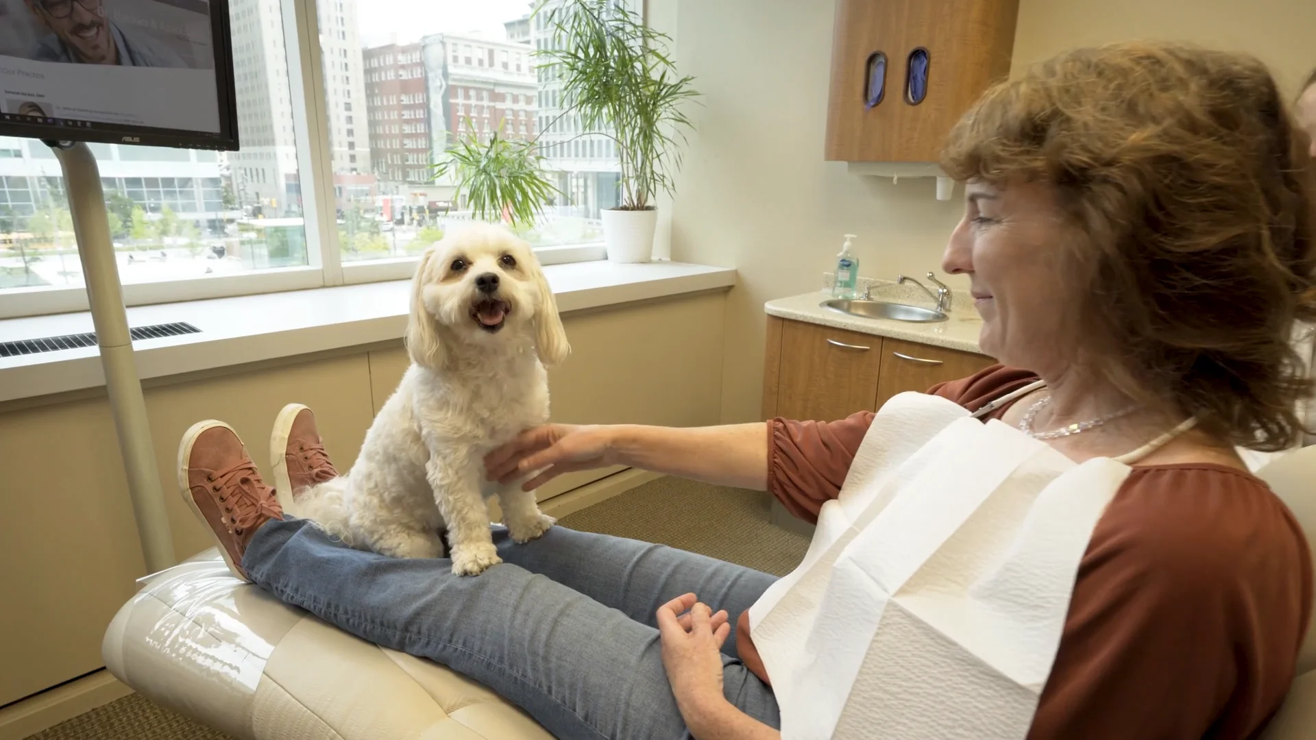 Dakota the therapy dog sitting on a patient's lap at Dr. Backiel and Associates