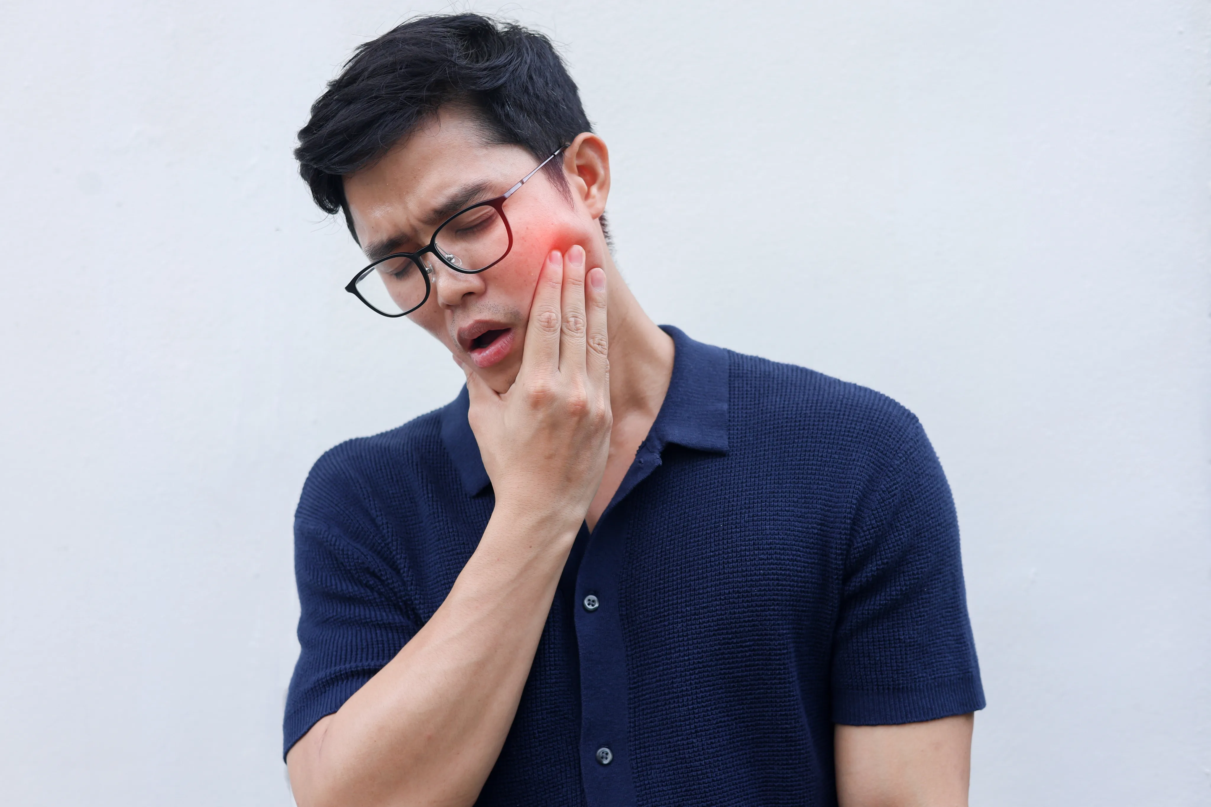 Man experiencing jaw pain from TMJ disorder